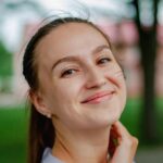 Portrait of a smiling woman enjoying a sunny day outdoors in Ukraine.
